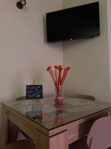 a table with a vase of flowers and a sign on it at Il Richiamo della Cascata in Papigno