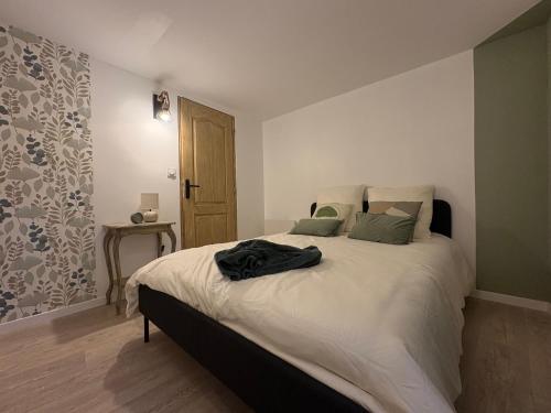 - une chambre dotée d'un lit avec une chemise noire dans l'établissement Le Domus Pesmois, à Pesmes