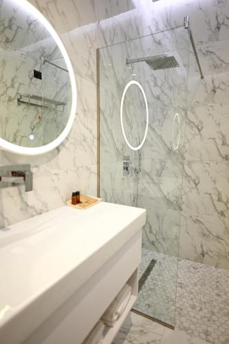 a bathroom with a white sink and a mirror at King & Queen Boutique Hotel in Fier