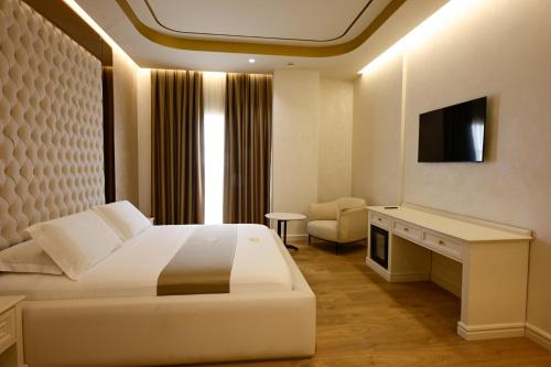 a hotel room with a bed and a television at King & Queen Boutique Hotel in Fier