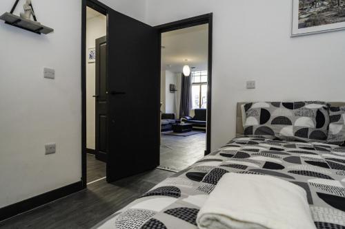 a bedroom with a black and white bed and a mirror at Di's Residence in Royal Tunbridge Wells