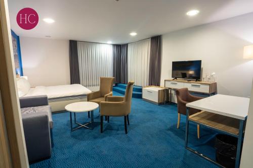 a hotel room with a bed and a tv at Central Hotel, Fitness and Spa in Vinica