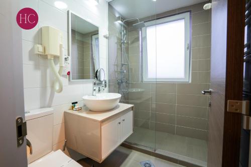 a bathroom with a sink and a glass shower at Central Hotel, Fitness and Spa in Vinica
