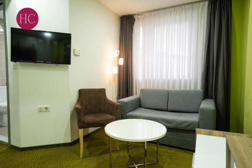 a living room with a couch and a table at Central Hotel, Fitness and Spa in Vinica