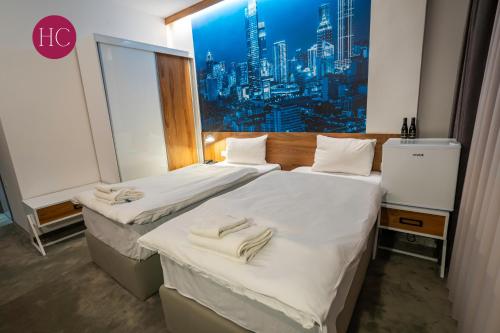 two beds in a room with a view of a city at Central Hotel, Fitness and Spa in Vinica