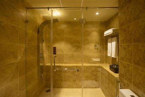 a bathroom with a shower with a glass door at Grandeeza Hotel by Galison in Negombo