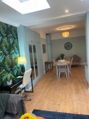 a living room and dining room with a table and chairs at Right by Leigh Broadway Private Garden large ground fl apt in Southend-on-Sea