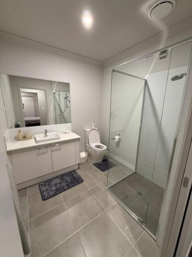 a bathroom with a shower and a sink and a toilet at Your Coastal Haven - Brand New Home by the Bay! in Deception Bay