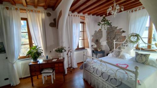 a bedroom with a bed and a desk and windows at jasmine cottage in Luni