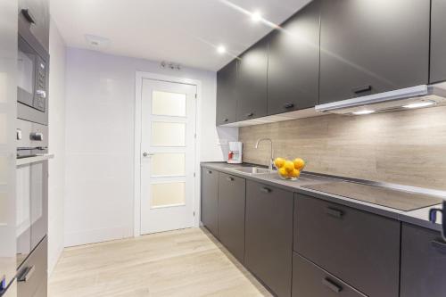 a kitchen with gray cabinets and a sink at Antonio Lopez en Madrid in Madrid