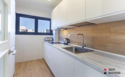 a kitchen with white cabinets and a sink at Antonio Lopez en Madrid in Madrid