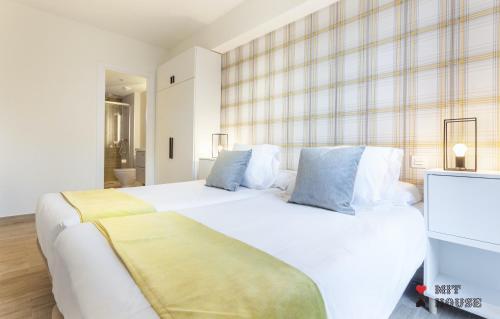 a bedroom with two white beds with blue pillows at Antonio Lopez en Madrid in Madrid