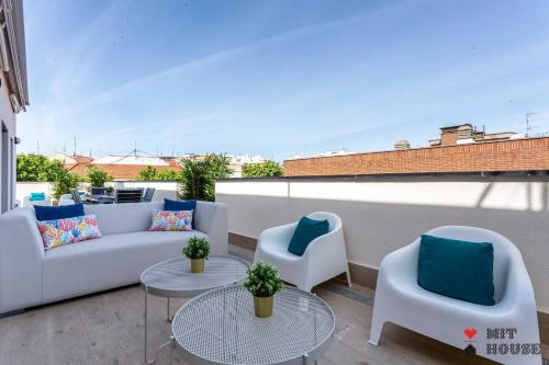 a patio with two couches and two tables and chairs at Antonio Lopez en Madrid in Madrid