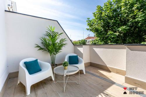 a balcony with two chairs and a table and a plant at Antonio Lopez en Madrid in Madrid