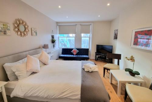 a bedroom with a large bed and a living room at Notting Hill 2 Bed Flat - 5 min to Portobello Road in London