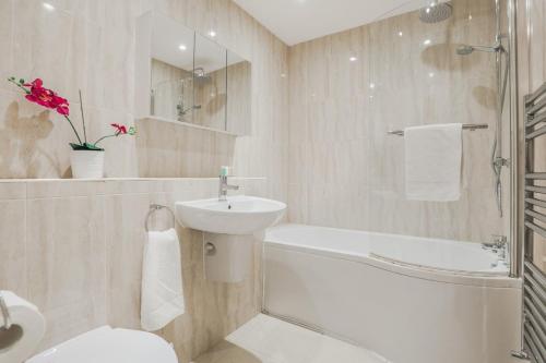 a bathroom with a sink and a toilet and a bath tub at Notting Hill 2 Bed Flat - 5 min to Portobello Road in London