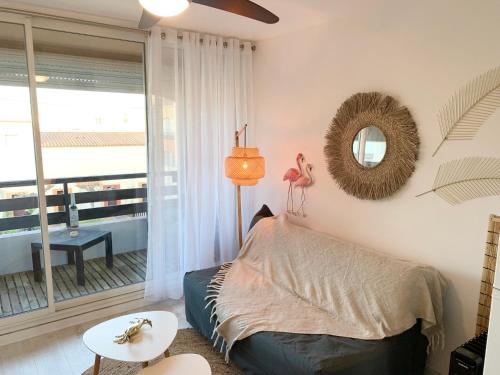 une chambre avec un lit, une table et un miroir dans l'établissement Studio vue port et mer Cap d'Agde île des Pêcheurs, au Cap d'Agde