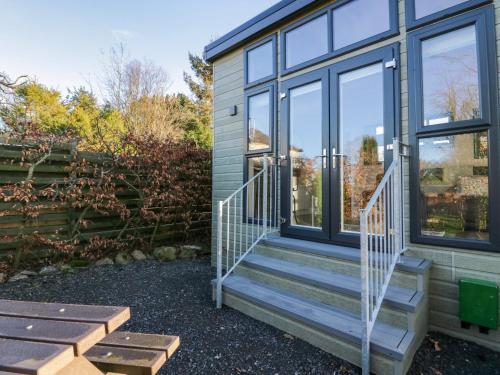 a house with a staircase next to a window at Elderflower Lodge in Grange Over Sands