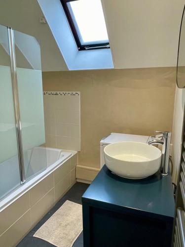 une salle de bain avec un lavabo et une baignoire dans l'établissement Appartement cosy proche gare, à Vannes
