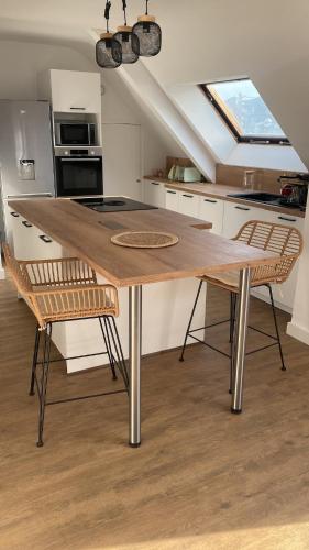 une cuisine avec une table en bois et deux chaises dans l'établissement Appartement cosy proche gare, à Vannes