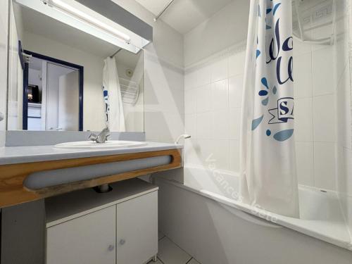 une salle de bain avec un lavabo et un rideau de douche dans l'établissement 1 CHAMBRE, DERNIER ETAGE AVEC ASC, CLIM, RES AVEC PISCINE, à Sète