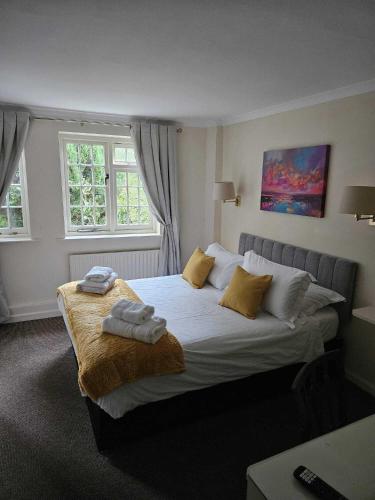 a bedroom with a large bed with towels on it at The Barford Inn in Salisbury