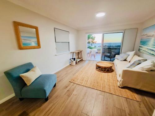 a living room with a couch and a chair at Perfect Oceanfront Cottesloe apartment in Perth