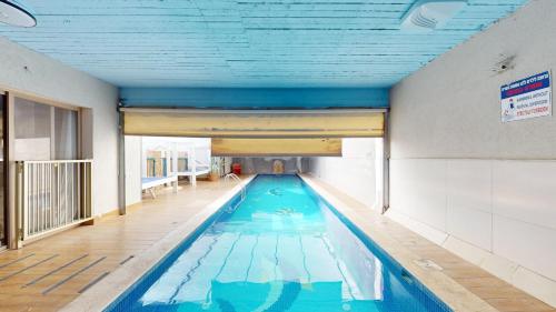 a swimming pool in a building with a blue ceiling at אחוזת ריצ'מונד של רשת לב הגולן - 3 סוויטות מהממות בחד נס ליד הכנרת עם בריכה משותפת מחוממת ומקורה in Had Nes