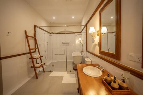 a bathroom with a sink and a glass shower at Clodagh Manor House by Seven Angels in Matale