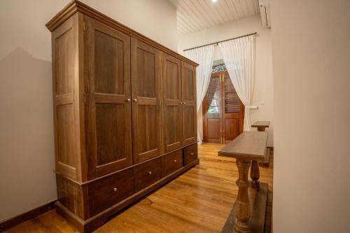 a large wooden cabinet in a room with a table at Clodagh Manor House by Seven Angels in Matale