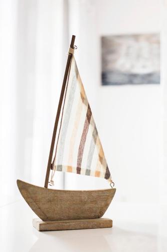 a wooden sailboat toy on a table at Urokliwy cichy apartament blisko morza in Świnoujście