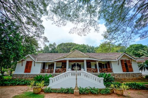 a white house with a porch and stairs at Clodagh Manor House by Seven Angels in Matale