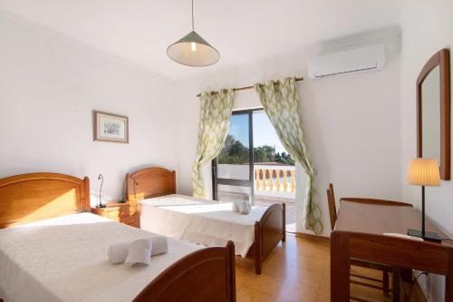 Una habitación de hotel con dos camas y una ventana. en Casa Das Figueiras, en Guia
