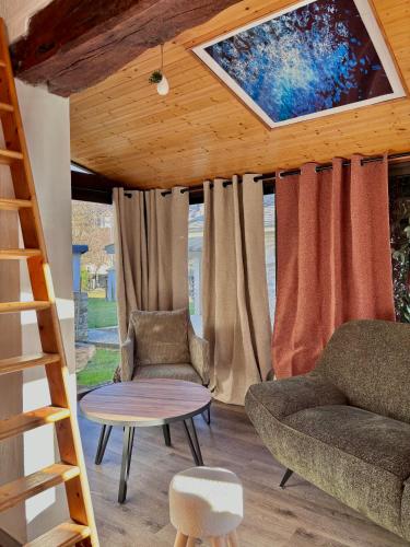 a living room with a couch and a ladder at Le Hourmigué maison avec jacuzzi à 15mn de Luchon in Cierp