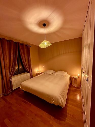 a bedroom with a large bed and a ceiling at Le Hourmigué maison avec jacuzzi à 15mn de Luchon in Cierp