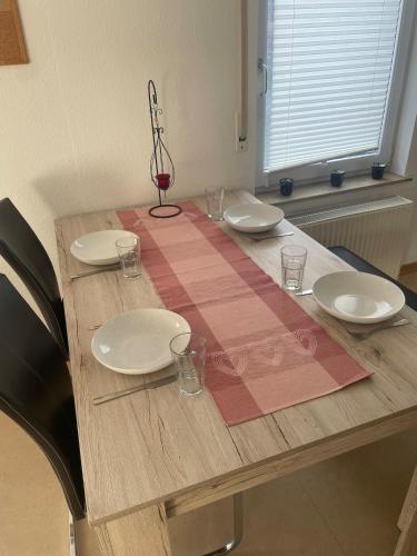 a wooden table with plates and glasses on it at Ferienwohnung im Herzen von Walldürn in Walldürn