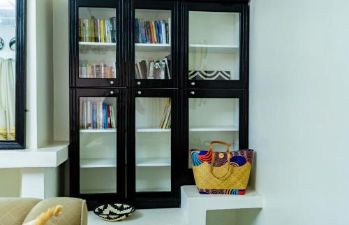 a black book shelf with books in it at Blue Veil Villa Hotel in Kigali