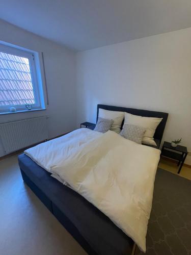 a large bed in a bedroom with a window at Ferienwohnung im Herzen von Walldürn in Walldürn