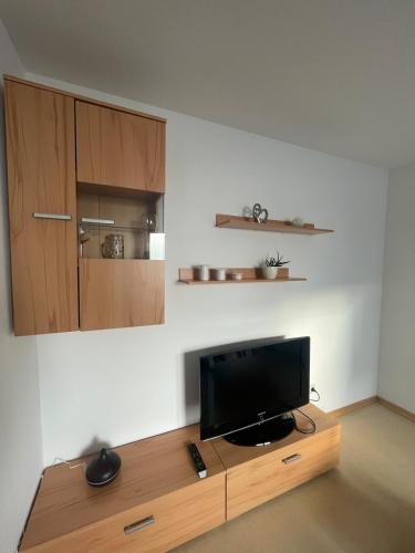 a television on a wooden stand in a room at Ferienwohnung im Herzen von Walldürn in Walldürn