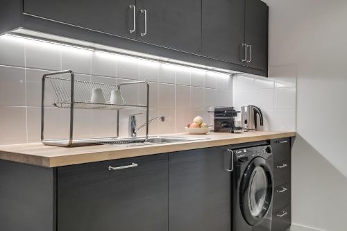 une cuisine avec un évier et une machine à laver dans l'établissement Sweett - Bonne Nouvelle, à Paris