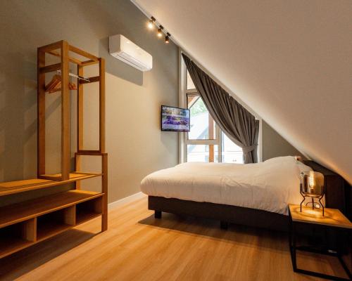 a bedroom with a bed and a staircase with a window at Bos Villa met Hottub & Sauna | 8 personen - Resort Valley in Wekerom