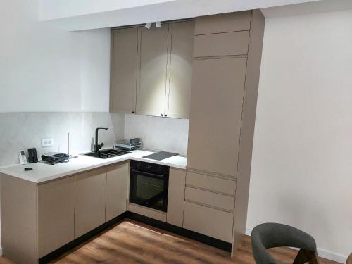 a kitchen with white cabinets and a stove top oven at D & O Apartments in Mavrovo
