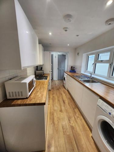 a kitchen with a sink and a microwave on a counter at Manor House 002 in Walsall