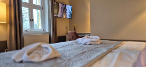 a bedroom with a bed with towels on it at Schlosshotel Hohenbocka in Hohenbocka