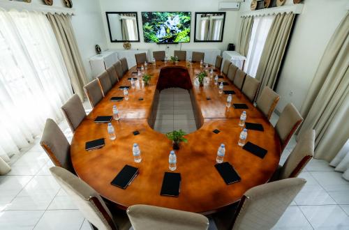 a large wooden table in a room with chairs at Blue Veil Villa Hotel in Kigali