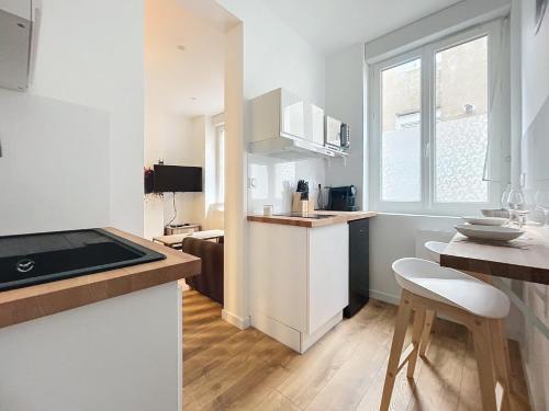 une cuisine avec des armoires blanches et un comptoir dans l'établissement beau T1 proche gare de Nantes, à Nantes