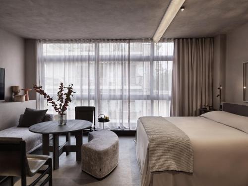 a hotel room with a bed and a table and a window at Monastik Living in Athina in Athens