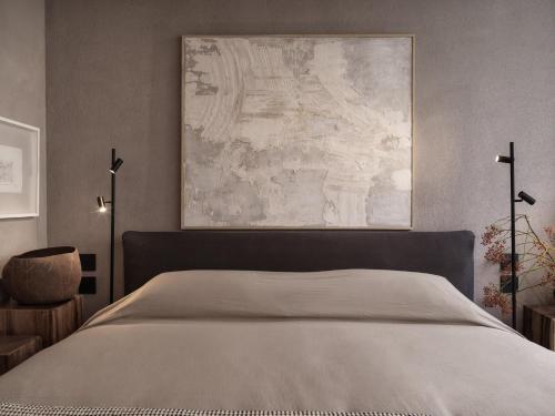 a bedroom with a bed and a painting on the wall at Monastik Living in Athina in Athens