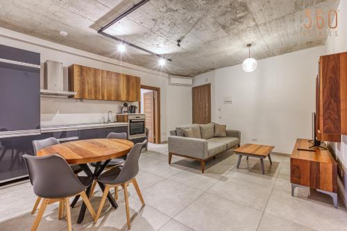 a kitchen and living room with a table and chairs at The Swieqi Poolside Suites in Is-Swieqi