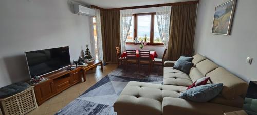 a living room with a couch and a flat screen tv at Bansko Pirin Golf & Country Club Blue Mountains View in Razlog
